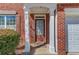 Inviting entryway featuring a brown front door with decorative pillars and brick facade at 1554 Park Grove Dr, Lawrenceville, GA 30046
