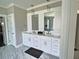 Modern bathroom with a double sink vanity, marble floors, and stylish lighting at 1952 Azalea Dr, Lawrenceville, GA 30043