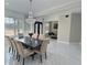 A dining room showcases a modern chandelier, large windows, marble flooring, and a sleek, black rectangular table at 1952 Azalea Dr, Lawrenceville, GA 30043