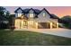 Striking two-story home showcases a brick facade, three-car garage, and professionally landscaped yard at 1952 Azalea Dr, Lawrenceville, GA 30043