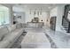 An open-concept living room flows into the kitchen with a large gray sofa and marble flooring throughout at 1952 Azalea Dr, Lawrenceville, GA 30043