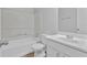 Bright bathroom featuring a tub and shower combination, plus a white single sink vanity at 2044 Teal Cv, Lithonia, GA 30058