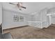 Neutral living room featuring a ceiling fan, large windows and cozy carpet at 2044 Teal Cv, Lithonia, GA 30058