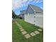 A well-manicured backyard with a white picket fence and a stone paver pathway to the house at 2467 Sky Valley Dr, Dacula, GA 30019