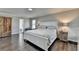 Bright bedroom featuring hardwood floors, a queen bed, and a wooden dresser at 2467 Sky Valley Dr, Dacula, GA 30019