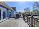 An outdoor deck featuring gray wood, black railings, and a partial view of the backyard at 2467 Sky Valley Dr, Dacula, GA 30019