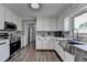 Bright kitchen featuring white cabinets, stainless steel appliances, and sleek countertops at 2467 Sky Valley Dr, Dacula, GA 30019