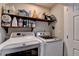 Bright laundry room with washer, dryer, and shelving for storage at 2467 Sky Valley Dr, Dacula, GA 30019