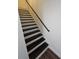 Stairway with dark wood steps and white risers and stringer along the wall at 2467 Sky Valley Dr, Dacula, GA 30019