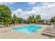 A stunning pool area with lounge chairs under the clear, blue skies and surrounded by lush trees at 130 Arizona Ne Ave # 302, Atlanta, GA 30307