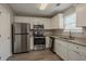 Bright kitchen features stainless steel appliances, white cabinets, and granite countertops at 201 Coral Cir, Mcdonough, GA 30253