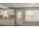 Bright eat-in kitchen with granite countertops, white cabinets, and stainless steel sink at 201 Coral Cir, Mcdonough, GA 30253
