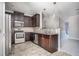 Open kitchen with stainless appliances, dark cabinets, and tile floors, flowing into the adjacent living area at 2544 Castellan Dr, Atlanta, GA 30316