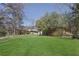 Expansive backyard featuring a well-maintained lawn, mature trees, and the exterior of a brick home at 2675 Davidson Dr, Lithonia, GA 30058