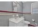 Well-lit bathroom with a white vanity, mirror, and neutral tile flooring at 2675 Davidson Dr, Lithonia, GA 30058