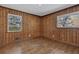 Cozy bedroom with natural wood walls, hardwood floors, and dual windows providing ample light at 2675 Davidson Dr, Lithonia, GA 30058