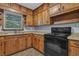 View of kitchen featuring wooden cabinets, and black stove with view to outside at 2675 Davidson Dr, Lithonia, GA 30058