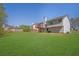 Expansive backyard with lush lawn, trees, and home with outdoor deck at 3021 Hampton Club Way, Lithonia, GA 30038