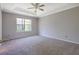 Spacious carpeted bedroom with a ceiling fan and a bright window at 3021 Hampton Club Way, Lithonia, GA 30038