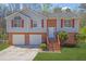 Charming home featuring a two-car garage, brick accents, and a welcoming front entrance with stairs at 3021 Hampton Club Way, Lithonia, GA 30038