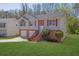 Exterior of home with lush green lawn, trees, driveway, and brick accents at 3021 Hampton Club Way, Lithonia, GA 30038