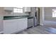 Well-lit kitchen with stainless steel refrigerator and dishwasher, with grey, woodgrain laminate floors at 3021 Hampton Club Way, Lithonia, GA 30038