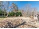 View of the vast backyard with a chain link fence and manicured green shrubs and trees at 537 Pine Shadows Dr, Dallas, GA 30157