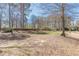 Spacious backyard with trees and a covered patio at 537 Pine Shadows Dr, Dallas, GA 30157