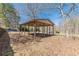 Carport surrounded by dry leaves and a wooden privacy fence at the property line at 537 Pine Shadows Dr, Dallas, GA 30157