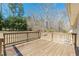 View of a wooden deck with railing overlooking a vast backyard with tall trees and shrubbery at 537 Pine Shadows Dr, Dallas, GA 30157
