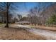 Peaceful view of a single-story home featuring a driveway and set in a wooded location at 537 Pine Shadows Dr, Dallas, GA 30157