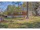 A view of the backyard features a brick house with many windows, a lush lawn, and mature trees, providing a private outdoor space at 2261 Headland Ter, Atlanta, GA 30344
