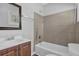 This is a bathroom with a white sink, wood cabinets, a black framed mirror, and a tiled shower and tub at 2261 Headland Ter, Atlanta, GA 30344