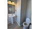 Half bathroom with pedestal sink, wood framed mirror, and gray plank accent wall at 2295 Golden Valley Dr, Lawrenceville, GA 30043