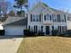 Charming two-story home with a well-manicured lawn, attached garage, and welcoming front entrance at 2295 Golden Valley Dr, Lawrenceville, GA 30043