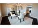 Elegant dining room features a glass-top table, white chairs, and an eye-catching chandelier at 3557 Bryant Meadow Cir, Buford, GA 30519