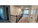 Hallway with plush carpets, wood and metal stair railings, and multiple doors creates a comfortable pathway at 3557 Bryant Meadow Cir, Buford, GA 30519