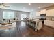 Open-concept living room features stylish furniture, a fireplace, and views into the modern kitchen at 3557 Bryant Meadow Cir, Buford, GA 30519