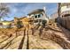 Multi-tiered backyard featuring a stone patio, landscaped terraces, and wrought iron stair rails, offering privacy at 6921 Springbank Way, Stone Mountain, GA 30087