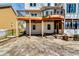 Expansive backyard with a tiered stone patio, deck, sunroom, and an outdoor ceiling fan for relaxation at 6921 Springbank Way, Stone Mountain, GA 30087