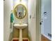 Cozy powder room featuring pedestal sink, gold fixtures, and an oval mirror for guests at 6921 Springbank Way, Stone Mountain, GA 30087