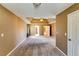 Large primary bedroom featuring tray ceiling with fan, neutral walls, and ample carpeted floorspace at 6921 Springbank Way, Stone Mountain, GA 30087