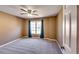 Neutral-toned bedroom featuring a ceiling fan, window with curtains, and neutral carpeting at 6921 Springbank Way, Stone Mountain, GA 30087