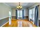 Dining room with hardwood floors, classic chandelier, and large windows with beautiful draperies at 6921 Springbank Way, Stone Mountain, GA 30087