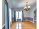 Elegant dining room with hardwood floors, stylish chandelier, and large windows with curtains at 6921 Springbank Way, Stone Mountain, GA 30087