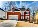 Charming two-story brick home with a well-manicured front yard and attached two-car garage at 6921 Springbank Way, Stone Mountain, GA 30087