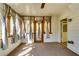 Bright sunroom with a ceiling fan, plush carpeting, paneled walls, and decorative curtains enhancing natural light at 6921 Springbank Way, Stone Mountain, GA 30087