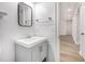 Simple bathroom with white walls, wood floor, modern sink and hardware, plus an open view down the hallway at 7985 Thunder River Way, Cumming, GA 30028