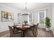 Dining room featuring wood floors, a modern chandelier, and wainscoting at 7985 Thunder River Way, Cumming, GA 30028