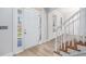 Bright foyer featuring wood floors, an elegant staircase, and sidelight windows around the front door at 7985 Thunder River Way, Cumming, GA 30028